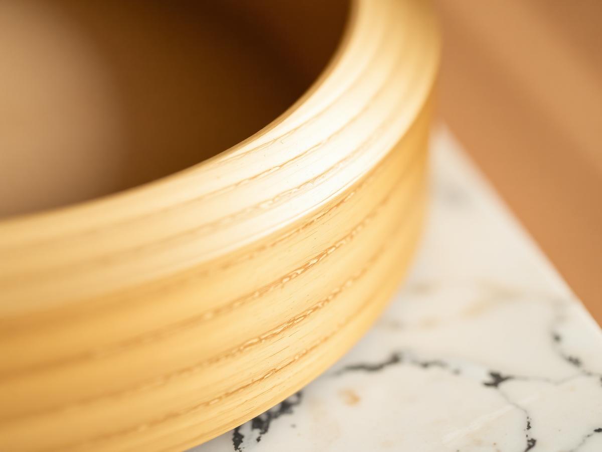 Macro detail of brushed brass meeting solid oak on a HousArc lamp
